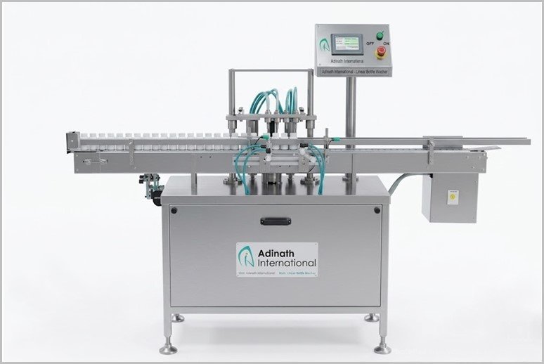 Industrial bottling machine with conveyor belt and vertical filling heads on stainless steel stand (Adinath International)