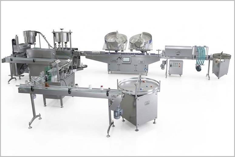 Automated stainless-steel bottle filling and capping line with conveyors and a rotary table for processing containers.