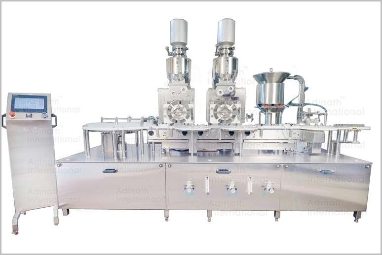 Automated liquid filling line with two filling heads on a stainless steel production table and a touchscreen control panel on the left side.