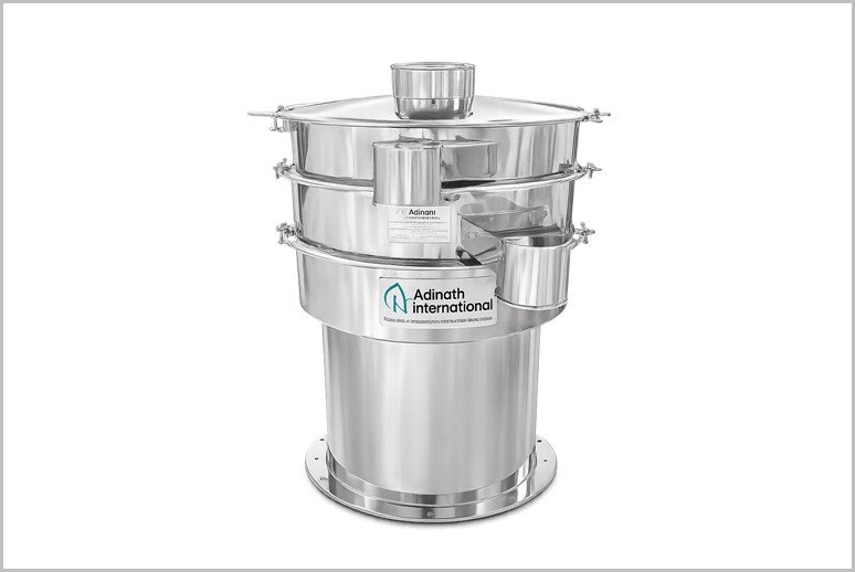 Stainless steel multi-tiered industrial dryer with stacked circular trays and a cylindrical base, branded Adinath International.