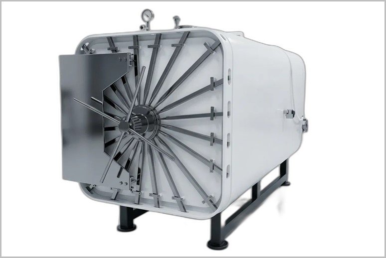 Large industrial autoclave/steam sterilizer with a circular spoked front door on a steel stand.