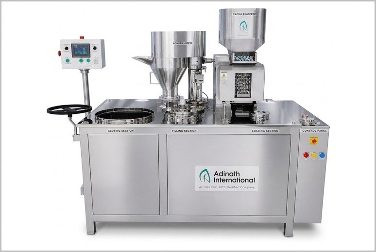 Stainless steel capsule filling machine with hoppers, control panel, and Adinath International branding